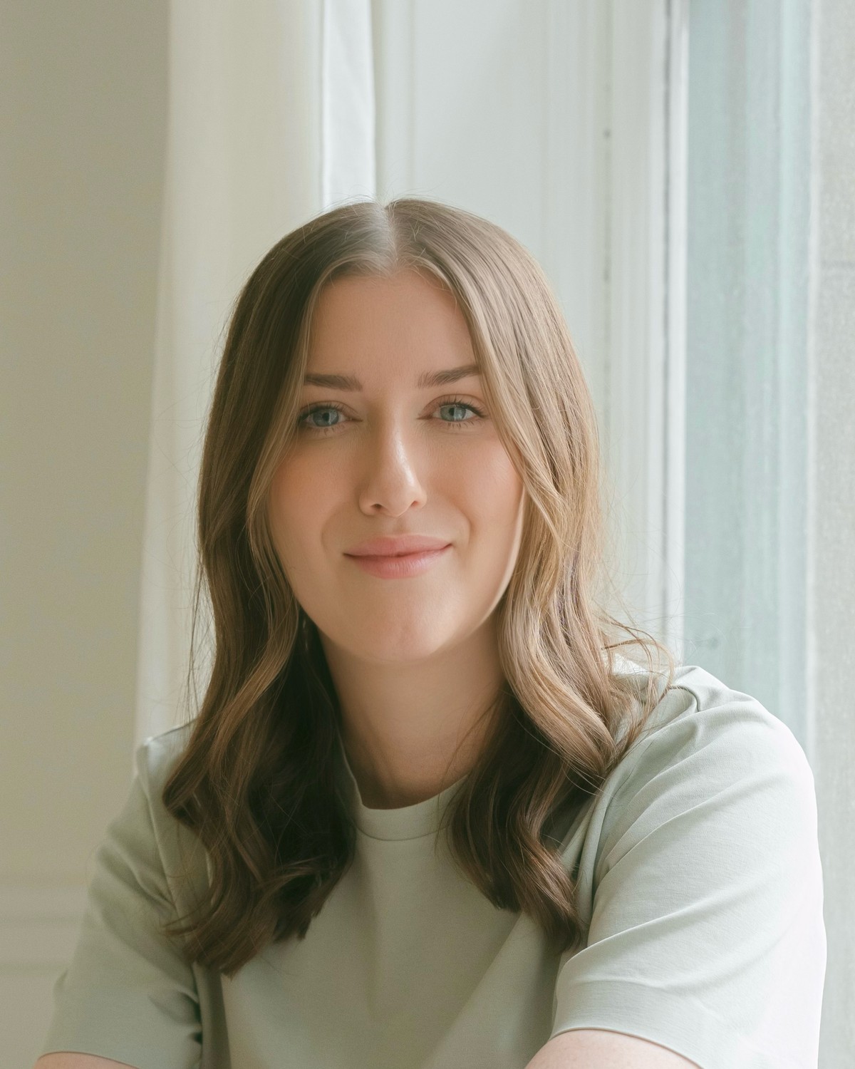 Portrait of Jackie Larkin, Canadian Certified Counsellor, smiling by a bright window